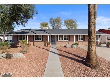 Charming single-story home with a gravel front yard and mature trees in a sunny setting at 3724 E Joan De Arc Ave, Phoenix, AZ 85032