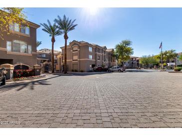 Beautiful exterior view of the community entrance with paved roads, palm trees, and well-maintained landscaping at 4455 E Paradise Village S Pkwy # 1068, Phoenix, AZ 85032