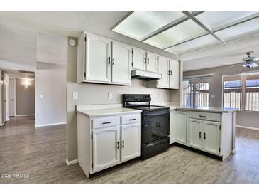 Well-lit kitchen with white cabinets, laminate counters and stainless steel appliances at 4536 W Bloomfield Rd, Glendale, AZ 85304