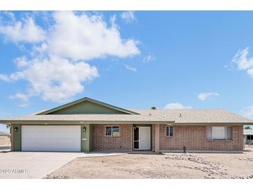 Charming single-story brick home featuring an attached two-car garage and tidy desert landscaping at 6308 E Billings St, Mesa, AZ 85205