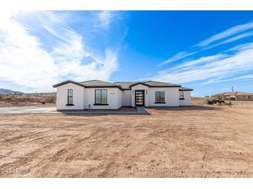Stunning single-story home featuring a modern design, desert landscaping, and a spacious front yard at 13012 S 218Th Ave, Buckeye, AZ 85326