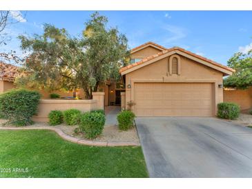 Charming home with a well-manicured lawn, mature trees, and a two-car garage at 16002 N 50Th St, Scottsdale, AZ 85254