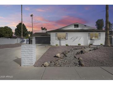 Charming single-Gathering home showcasing a white brick exterior with desert landscaping at 1716 W Butler Dr, Phoenix, AZ 85021