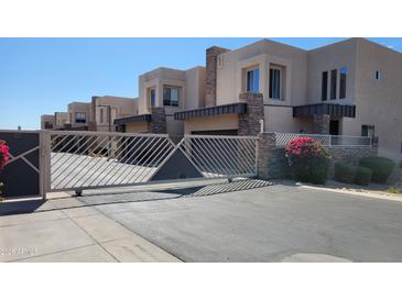 Elegant stucco townhomes feature stone accents and a secure gated entrance, providing privacy and curb appeal at 2241 E Pinchot Ave # B3, Phoenix, AZ 85016