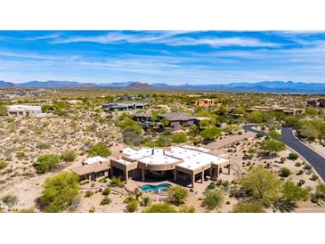 Stunning aerial view of luxury home with private pool, desert landscaping and mountain views on a sunny day at 24548 N 121St Pl, Scottsdale, AZ 85255
