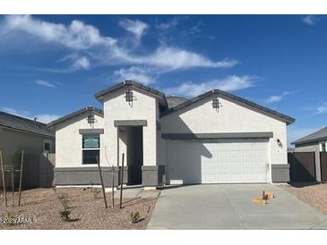 Charming single-story home featuring a two-car garage, neutral paint, and a well-manicured front yard at 25430 W Graham Trl, Buckeye, AZ 85326