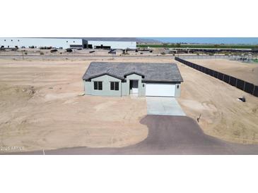 Single-story home featuring a gray stucco exterior, a gray roof, and an attached two-car garage at 6250 S Dean Rd, Buckeye, AZ 85326