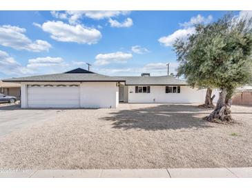 Charming single-story home featuring a white exterior, gravel landscaping, and an attached garage at 7745 N 33Rd Ave, Phoenix, AZ 85051