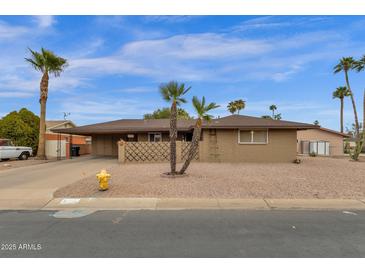 Charming home featuring desert landscaping, palm trees, and a covered carport at 915 S Saranac Ave, Mesa, AZ 85208