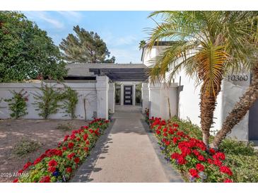 Inviting home entrance with desert landscaping and a decorative pergola over a walkway to the front door at 10360 N 98Th St, Scottsdale, AZ 85258