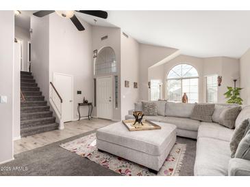 Bright living room featuring a vaulted ceiling, large windows, and a comfortable sectional sofa at 13232 W Ironwood St, Surprise, AZ 85374