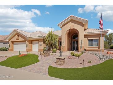 Charming single-story home with a well-manicured desert landscape, beautiful walkway, and a welcoming arched entryway at 14110 W Robertson Dr, Sun City West, AZ 85375