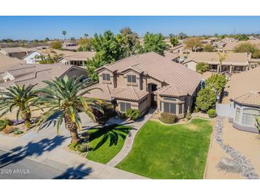 Stunning two-story home featuring well-kept lawn and mature palm tree at 1446 E Oxford Ln, Gilbert, AZ 85295