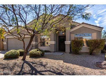 Charming single-story home with desert landscaping, a covered entryway, and a two-car garage at 2525 E Misty Willow Ln, Phoenix, AZ 85024