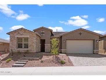 Charming single-story home featuring stone accents, a two-car garage, and a landscaped front yard at 32489 N 135Th Dr, Peoria, AZ 85383