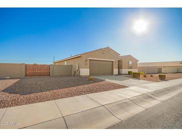 Charming single-story home featuring a two-car garage, desert landscaping, and a private fenced side yard at 4459 E Warlander Ln, San Tan Valley, AZ 85140