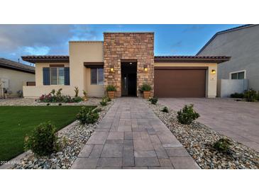 Inviting single Gathering home with manicured lawn, stone accents, and a two-car garage at 6225 S Boulder St, Gilbert, AZ 85298