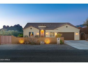 Inviting home exterior with unique design elements and desert landscaping, against a mountain backdrop at 10142 E La Palma Ave, Gold Canyon, AZ 85118