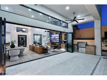 Stunning indoor/outdoor living space with a large folding glass door, custom built-ins, and tiled floors at 11578 N 80Th Pl, Scottsdale, AZ 85260