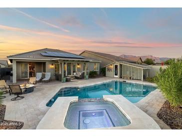 Relaxing backyard oasis features a pool, spa, covered patio, fire pit, and mountain views at 12031 E Chevelon Trl, Gold Canyon, AZ 85118