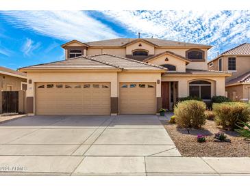 Charming two-story home boasts a spacious three-car garage and well-maintained front yard at 1213 W Deoni Trl, San Tan Valley, AZ 85143