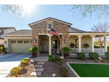 Charming single-story home with stone facade, covered porch, and well-maintained landscaping at 20421 W Legend Trl, Buckeye, AZ 85396
