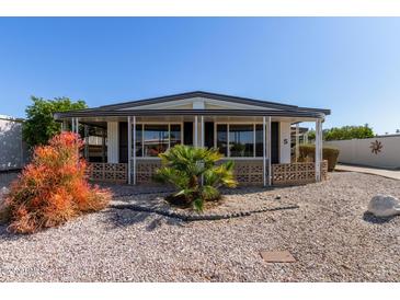 Charming single-story home featuring a well-maintained yard with desert landscaping and a welcoming front porch at 3160 E Main St # 5, Mesa, AZ 85213