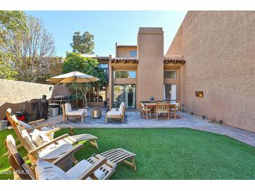 Inviting backyard with a patio, outdoor seating, a grill, and artificial grass, perfect for entertaining and relaxation at 4434 E Camelback Rd # 132, Phoenix, AZ 85018