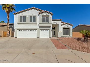 Charming two-story home featuring a three-car garage, landscaped front yard, and a classic stucco finish at 10616 E Carol Ave, Mesa, AZ 85208