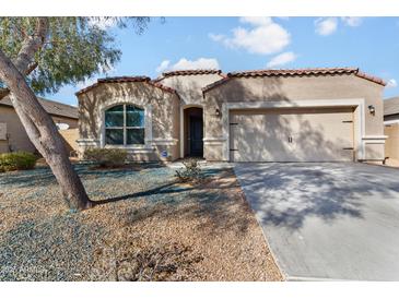 Charming single-story home with a two-car garage, neutral stucco, and terracotta roof tiles at 13624 W Desert Moon Way, Peoria, AZ 85383