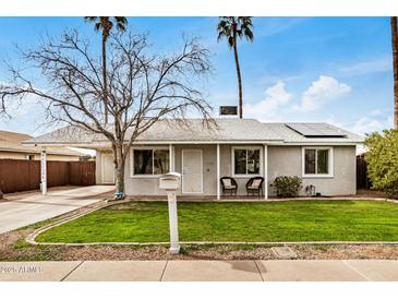 Charming home featuring a well-maintained lawn and covered carport at 14008 N 61St Ave, Glendale, AZ 85306