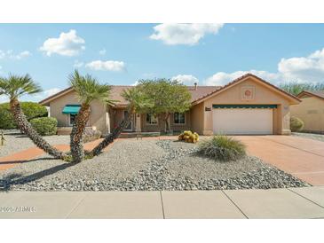 Single-story home featuring desert landscaping, attached garage, and a neutral color palette at 14432 W Yukon Dr, Sun City West, AZ 85375