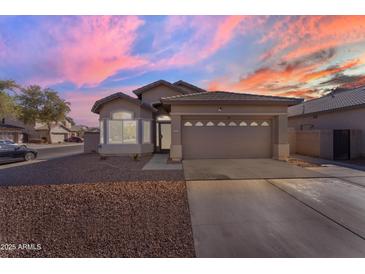 Charming single-story home featuring a two-car garage, low maintenance desert landscaping, and a tile roof at 151 N 116Th Dr, Avondale, AZ 85323