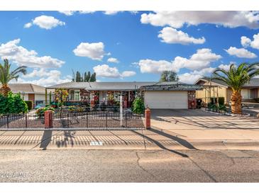 Charming single-story home with stone accents, a well-manicured front yard, and a covered carport at 238 N 62Nd St, Mesa, AZ 85205