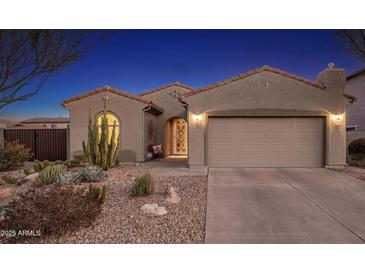 Charming stucco home featuring a desert landscape, two-car garage, and a welcoming front entrance at 25609 N 54Th Ln, Phoenix, AZ 85083