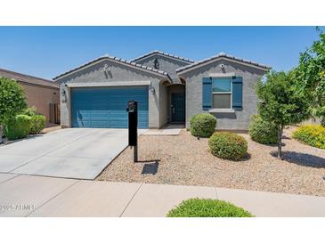 Charming single-story home with a well-manicured front yard and inviting blue garage door at 40176 W Williams Way, Maricopa, AZ 85138