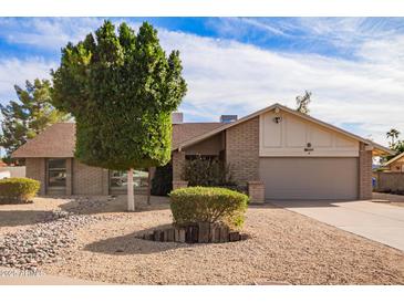 Charming single-story home featuring desert landscaping and a brick exterior at 4409 E Gelding Dr, Phoenix, AZ 85032