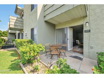 Inviting outdoor patio features a dining table and sliding glass door to the interior at 4620 N 68Th St # 111, Scottsdale, AZ 85251