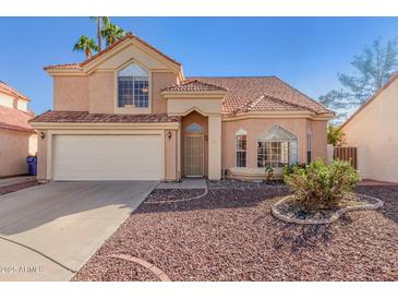 Charming two-story home featuring a tile roof, two car garage and low maintenance desert landscaping at 819 W Kyle E Ct, Gilbert, AZ 85233