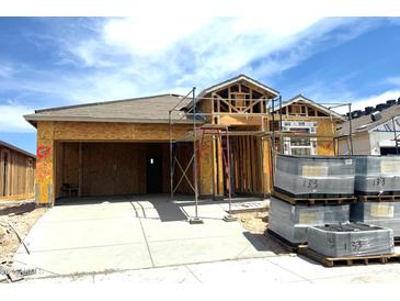New construction shows the home's frame with roofing tiles and a spacious two-car garage ready to be finished at 8452 W Clemente Way, Florence, AZ 85132