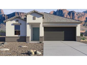 Single-story home featuring a two-car garage and desert landscaping with a mountain view at 8452 W Clemente Way, Florence, AZ 85132