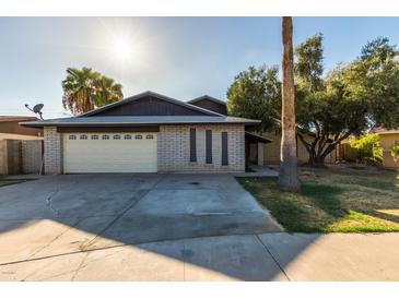 Charming single-story home with brick accents, a two-car garage and mature landscaping at 8626 N 50Th Ln, Glendale, AZ 85302