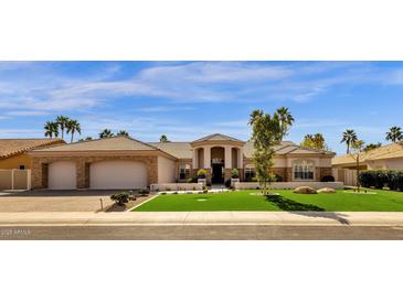 Stunning home showcasing a well-manicured lawn, stone accents, and a symmetrical facade at 8657 E Aster Dr, Scottsdale, AZ 85260