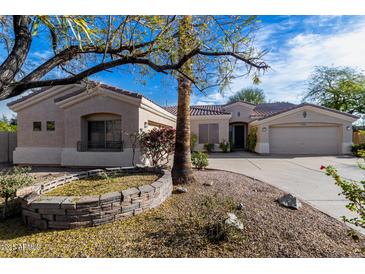 Charming single-story home with manicured desert landscaping, mature trees, and a welcoming facade at 9360 E Milagro Ave, Mesa, AZ 85209