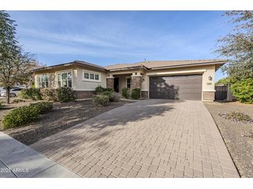 Charming single-story home featuring a two-car garage, desert landscaping, and a paver driveway at 14762 W Georgia Dr, Surprise, AZ 85379