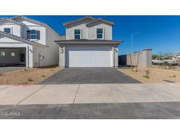 Inviting two-story home showcasing a brick driveway, desert landscaping, and a spacious two-car garage at 1588 N Pueblo Dr, Apache Junction, AZ 85120