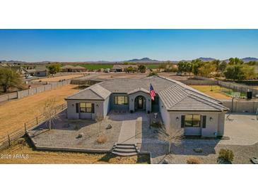 Charming single story home featuring immaculate desert landscaping and a grand entrance with an American flag at 21717 W South Mountain Ave, Buckeye, AZ 85326