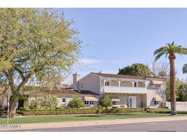 Charming two-story home features lush landscaping, a balcony, and a well-manicured lawn at 2233 N 9Th Ave, Phoenix, AZ 85007