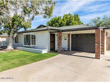 Charming single-story home with a brick and painted facade, well-maintained landscaping, and an attached garage at 5807 N 18Th St, Phoenix, AZ 85016