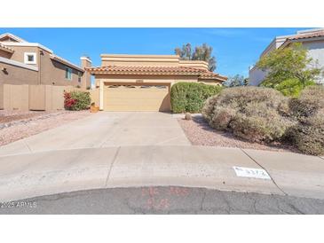 Charming single-story home featuring a two-car garage, desert landscaping, and a tile roof at 9372 E Aster Dr, Scottsdale, AZ 85260